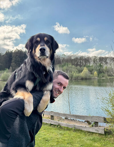 Hund auf Huckepack von Besitzer