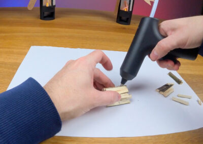 Holzscheite aus Haselnussast mit Heißklebepistole zusammenkleben