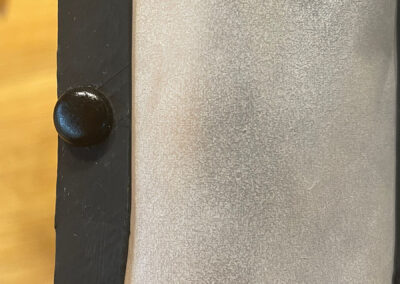 Schwarze Musterbeutelklammer von außen als Türgriff an der Kamintür