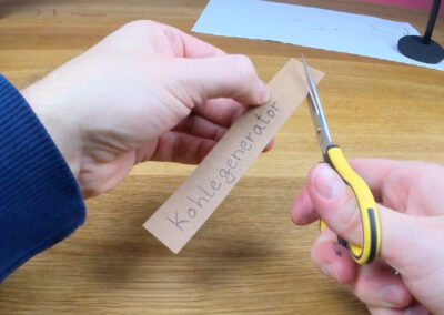 Schild mit Aufschrift Kohlegenerator aus Kraftpapier ausschneiden