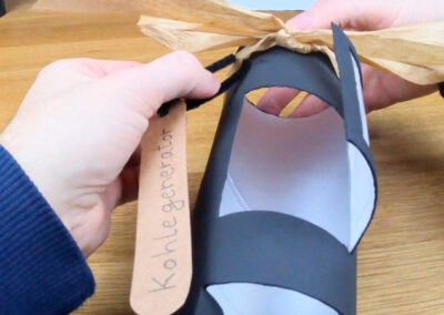 Kraftpapier Schild mit Aufschrift Kohlegenerator an Schleife des DIY Kamins befestigt