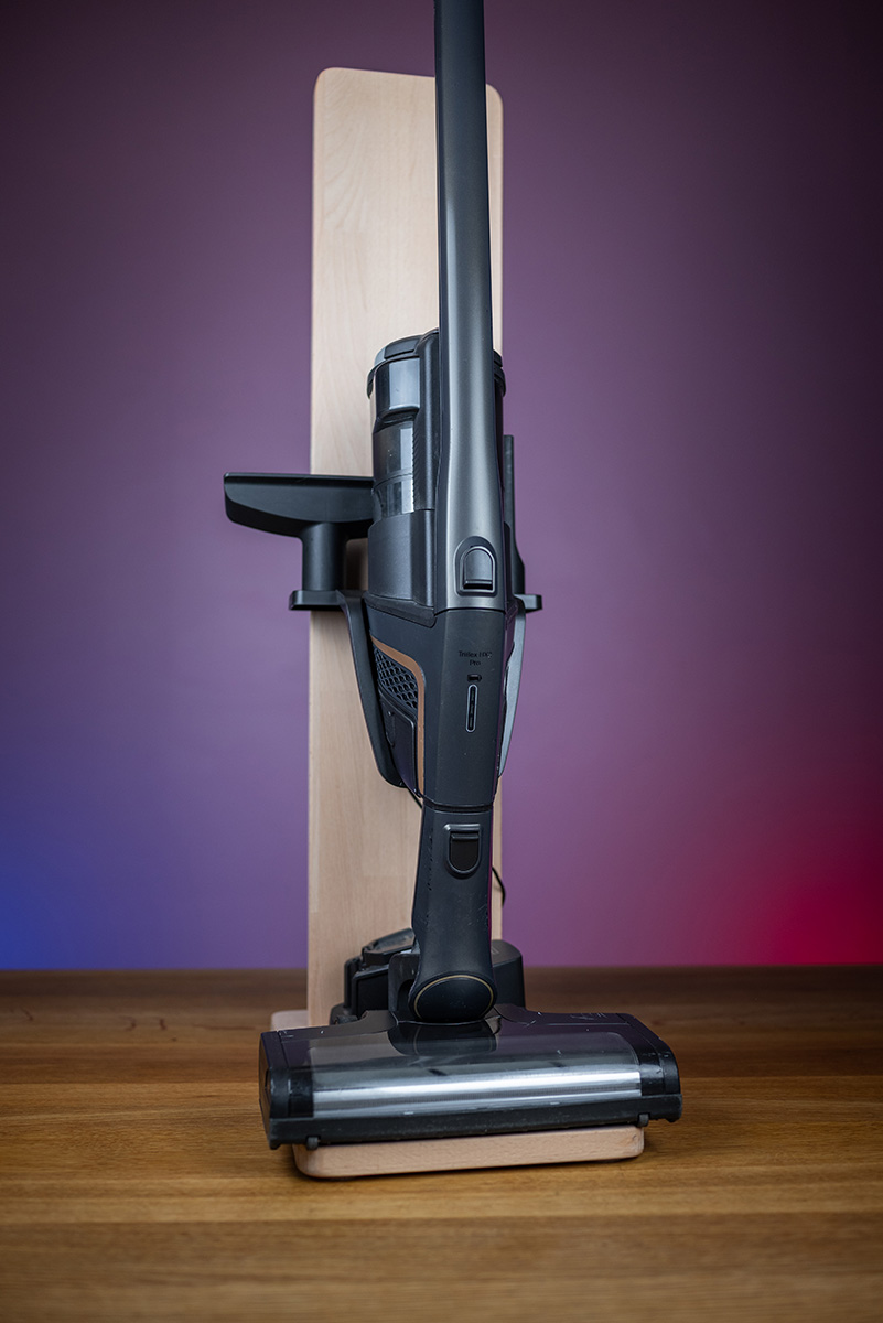 Staubsaugerständer aus Holz Ein freistehender Staubsaugerständer aus hellem Holz mit montiertem Akkusauger.