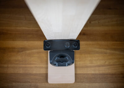 Ein Tuch trägt transparentes Holzöl auf die Oberfläche eines hellen Brettes auf.